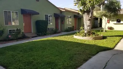 a green house with a tree in the yard at Victory Motel Inn near Universal & Hollywood in Glendale