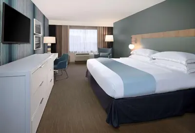 a hotel room with a large bed and a television at SunCoast Hotel Anaheim, Tapestry Collection by Hilton in Anaheim