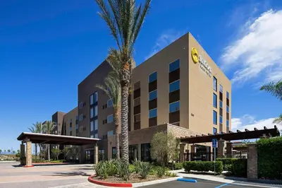 a hotel with a palm tree in front of a building at SunCoast Hotel Anaheim, Tapestry Collection by Hilton in Anaheim
