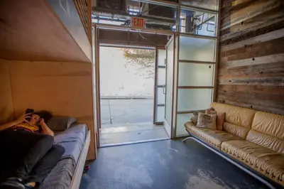 a person sitting on a couch in a room with a window at PodShare Hollywood in Los Angeles
