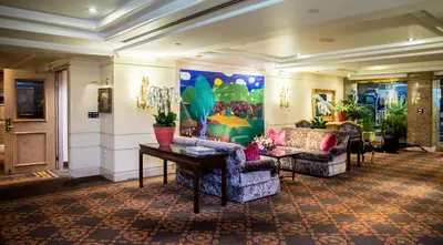 a lobby with two chairs and a table and a painting at Olyver Hotel in Los Angeles