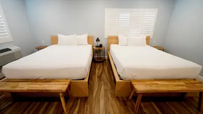 two beds sitting next to each other in a room at El Royale Gardens Near Universal Studios in Los Angeles