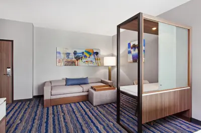 a living room with a couch and a mirror at SpringHill Suites by Marriott Huntington Beach Orange County in Huntington Beach