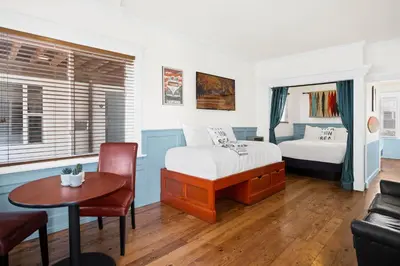 a bedroom with a bed and a table and a couch at Sea Blue Hotel in Los Angeles