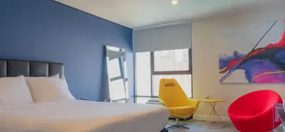 a bedroom with a bed and a yellow chair at Park Plaza Lodge in Los Angeles