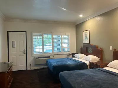 a hotel room with two beds and a window at Welcome Inn in Los Angeles