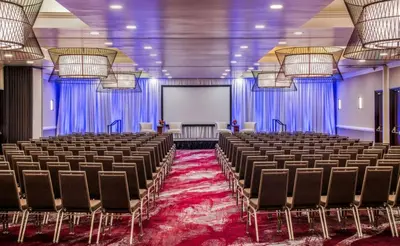a conference room with chairs and a white screen at Holiday Inn Oxnard - Ventura by IHG in Oxnard