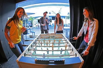 a group of people standing around a large billiard table at Banana Bungalow Hollywood Hotel & Hostel in Los Angeles
