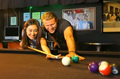 a man and a woman playing a game of pool at Banana Bungalow Hollywood Hotel & Hostel in Los Angeles