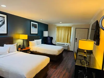 a hotel room with two beds and a television at Baymont by Wyndham Bakersfield in Bakersfield