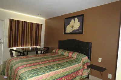 a hotel room with a bed and a table at Florentina Motel - Los Angeles in Los Angeles