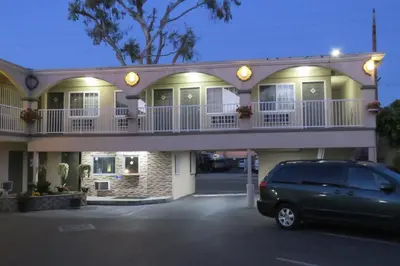 a car parked in a parking lot in front of a building at Florentina Motel - Los Angeles in Los Angeles