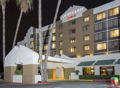 a hotel building at night with palm trees at Courtyard by Marriott Riverside UCR/Moreno Valley Area in Riverside