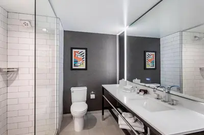 a bathroom with a toilet and a sink and a mirror at Cambria Hotel LAX in El Segundo