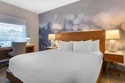 a hotel room with a bed and a desk and a window at Cambria Hotel LAX in El Segundo