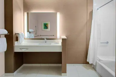 a bathroom with a sink and a mirror and a tub at Fairfield Inn & Suites by Marriott Bakersfield North/Airport in Bakersfield