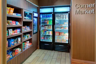 a grocery store aisle with two large refrigerators at Fairfield Inn & Suites by Marriott Bakersfield North/Airport in Bakersfield