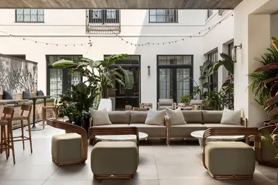 a living room with a couch and tables and chairs at Kimpton La Peer Hotel West Hollywood by IHG in Los Angeles
