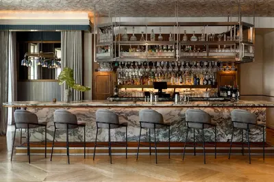 a bar with gray stools in a room at Kimpton La Peer Hotel West Hollywood by IHG in Los Angeles