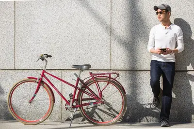 a man is standing next to a red bike at Kimpton La Peer Hotel West Hollywood by IHG in Los Angeles