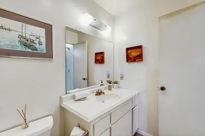 a white bathroom with a sink and a mirror at Sugar Shack in Carpinteria