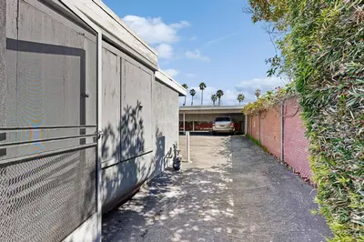 an alley with a fence next to a building at Sugar Shack in Carpinteria