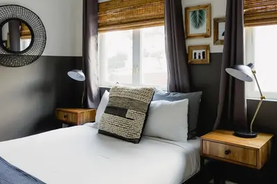 a bedroom with a bed with two lamps and a window at Noon on Sunset Hill in Los Angeles