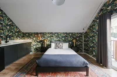 a bedroom with a bed and a wall of wallpaper at Noon on Sunset Hill in Los Angeles