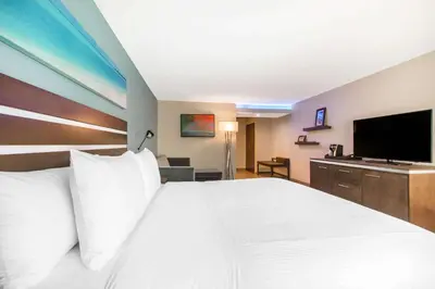 a hotel room with a large bed and a flat screen tv at The Cove Hotel in Long Beach