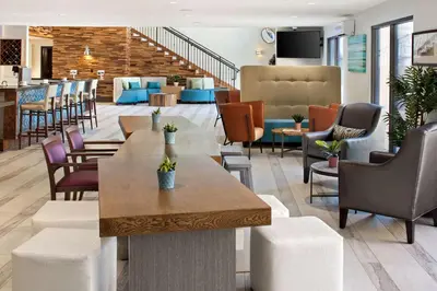 a lobby of a hotel with tables and chairs at The Cove Hotel in Long Beach