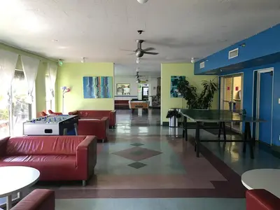 a living room with couches and a ping pong table at Banana Bungalow West Hollywood Hotel & Hostel in Los Angeles