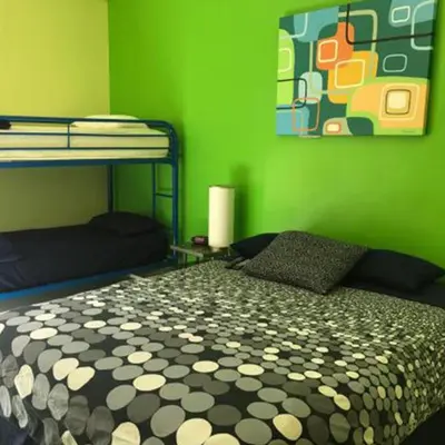 a green room with a bed and a green wall at Banana Bungalow West Hollywood Hotel & Hostel in Los Angeles