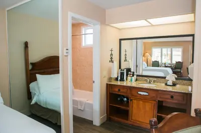 a bathroom with a sink and a bed and a mirror at Casa Ojai Inn in Ojai