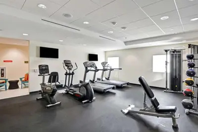 a gym with several cardio machines in a room at Home2 Suites Azusa in Azusa