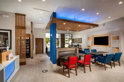 a dining room with red chairs and a table at Holiday Inn Express & Suites Chatsworth by IHG in Chatsworth