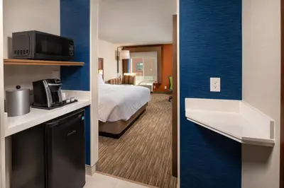 a hotel room with a bed and a room with a bathroom at Holiday Inn Express & Suites Chatsworth by IHG in Chatsworth