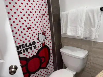 a bathroom with a toilet with a hello kitty shower curtain at The Dixie Hollywood in Los Angeles