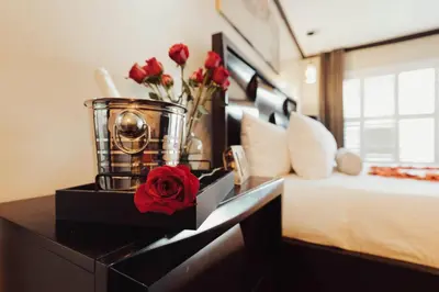 a bedroom with a bed and a table with flowers at The Dixie Hollywood in Los Angeles