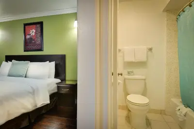 a bathroom with a bed and a toilet in a room at Vagabond Inn San Pedro in San Pedro
