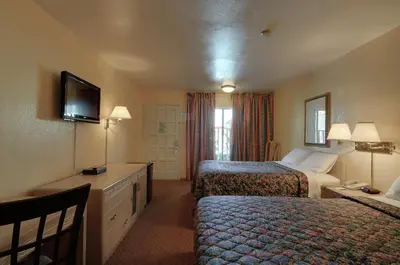 a hotel room with two beds and a television at Vagabond Inn San Pedro in San Pedro