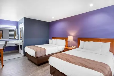 a hotel room with two beds and a bathroom at Quality Inn Near Hollywood Walk of Fame in Los Angeles