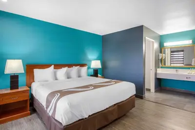 a bedroom with a large bed with a blue wall at Quality Inn Near Hollywood Walk of Fame in Los Angeles