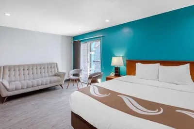 a hotel room with a large bed and a couch at Quality Inn Near Hollywood Walk of Fame in Los Angeles