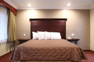 a hotel room with a bed with a large headboard at Budget Inn Anaheim near Disneyland Drive in Anaheim