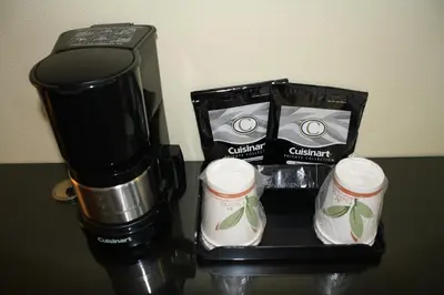 a coffee maker and two cups on a table at Hotel Current in Long Beach
