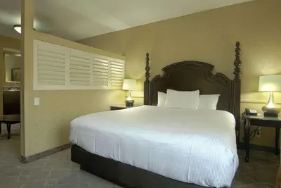 a bedroom with a large bed with white sheets and pillows at Azure Hotel&Suites Ontario Trademark Collection by Wyndham in Ontario