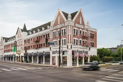 a building on the corner of a street with a car at Hollywood Historic Hotel in Los Angeles