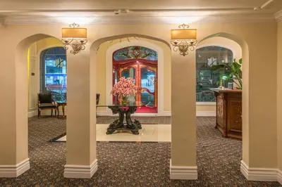 a room with three arches and a vase with flowers in it at Hollywood Historic Hotel in Los Angeles