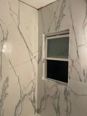 a small window in a bathroom with a marble wall at The Village in North Hollywood
