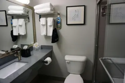 a bathroom with a toilet and a sink and a mirror at Hartford Hotel Best Western Signature Collection in Rosemead